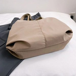 Grand sac cabas minimaliste en toile kaki pour femme présenté à plat sur fond blanc