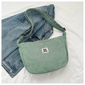 Detail of mint green corduroy bag showing the MF BEAR patch and fine ribbed texture