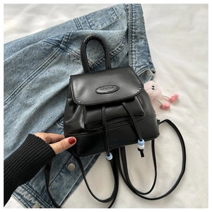 Detail of black mini backpack with logo, drawstring closure and blue bead accents