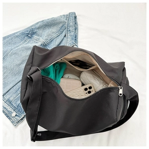 Détail intérieur du sac de voyage noir montrant les compartiments et le grand espace