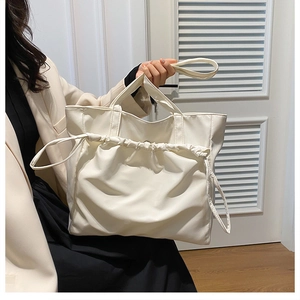 Detail of off-white tote bag with stylish drawstring pleated design for women fashion