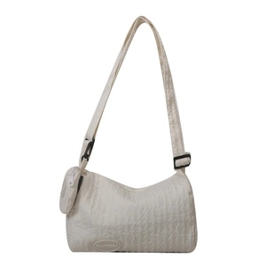 Cream nylon dumpling shoulder bag with adjustable strap and small round pouch charm