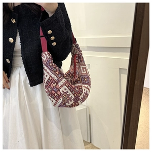 Close-up of bohemian style half-moon shoulder bag with geometric woven pattern
