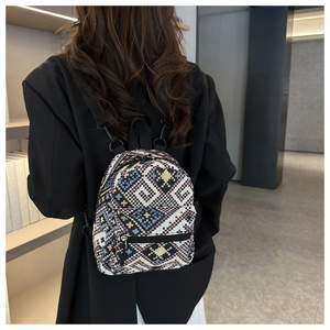 Détail du motif tissé ethnique et des fermetures éclair métalliques sur un sac en toile