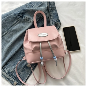 Detail of pink PU leather mini backpack with silver metal logo and decorative beads