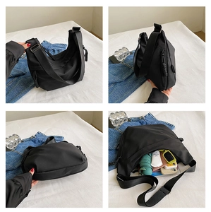 Detail view of large black nylon crescent bag showing interior capacity and adjustable strap