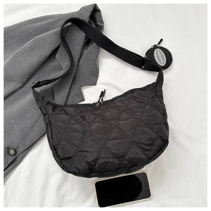 Detailed shot of a black quilted half-moon shoulder bag with a small round coin purse