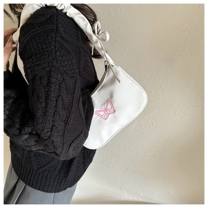 Gros plan du sac blanc avec broderie papillon rose et bandoulière plissée élégante