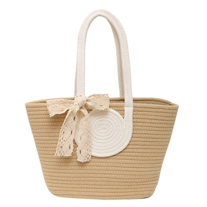 Beige woven tote bag with rope handles and a lace bow detail for summer styling