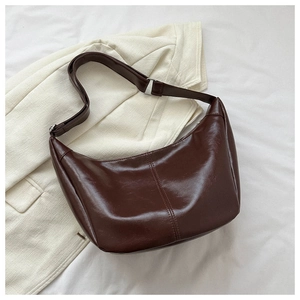 Détail du sac hobo en similicuir marron foncé avec boucle argentée et coutures doubles élégantes