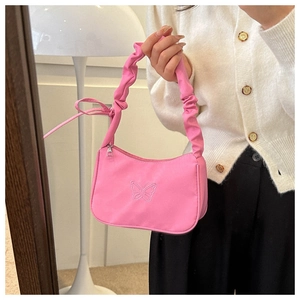 Détail du sac sous le bras en nylon rose avec broderie papillon et bandoulière nuage
