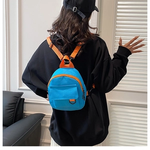 Gros plan d'un mini sac à dos en toile bleu vif avec des bordures orange contrastées