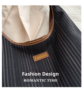Detail of striped woven tote bag featuring a leather Fashion tag and premium texture