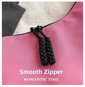 Detail of a smooth black zipper with double braided cord pullers on a pink oxford fabric bag