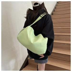 Minimalist light green oxford travel bag shown worn as a spacious crossbody shoulder bag