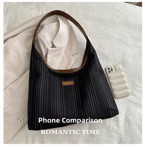 Detailed size comparison of a black textured tote bag against a modern smartphone