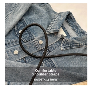 Detail of comfortable black padded shoulder strap on a washed denim shoulder bucket bag
