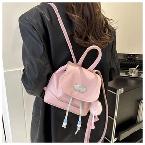 Pink mini backpack with silver PAUTOR logo plate and decorative fur ball pendant
