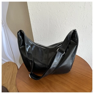 Détail d'un sac hobo noir avec doubles coutures verticales et fermeture éclair argentée