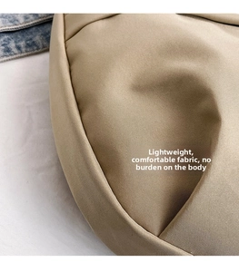Close-up of light khaki nylon fabric showing twill texture on a large crossbody bag