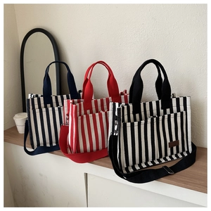 Striped canvas tote bags in navy, red, and black with double pockets and shoulder straps