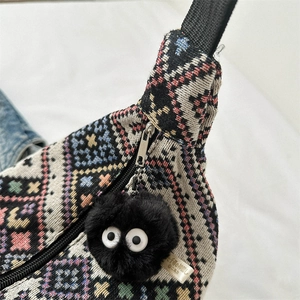 Ethnic style woven canvas crossbody bag with geometric patterns and plush coal charm