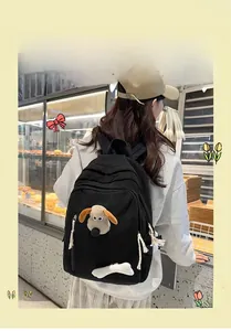 Detail of black corduroy backpack with cute cartoon plush and white bone charm accessory