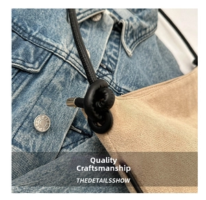 Detail of beige frosted leather bucket bag with knotted black strap and metal sealing