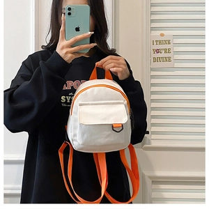 Mini sac à dos en toile blanche avec bretelles orange et boucle métallique sur la poche