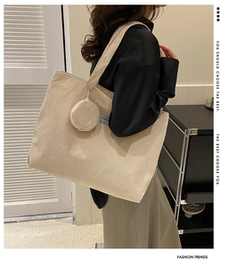 Detail of beige corduroy tote bag with matching coin purse on a stylish model