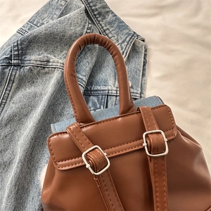 Retro brown faux leather backpack for women with round handles and metal buckle details