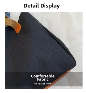 Detail of black canvas tote bag showing brown handle straps and premium fabric texture