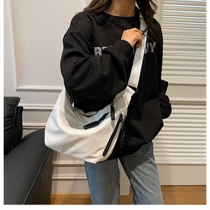 White nylon crossbody bag shown worn over a black sweater for a minimalist casual style