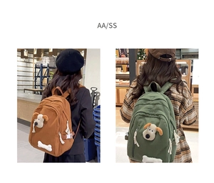 Detail of brown and green canvas backpacks with 3D cartoon puppy dog and bone design