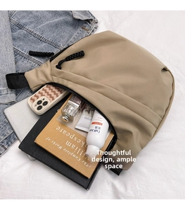 Spacious interior of khaki nylon crossbody bag showing books and daily essentials