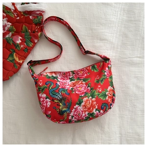 Detail of red floral canvas crossbody bag with traditional peony and phoenix patterns