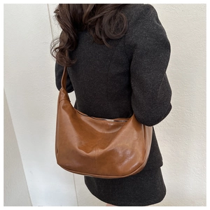 Sac croissant marron sur modèle montrant la taille et la forme souple en vue latérale