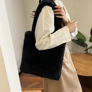 Detail of soft black faux fur tote bag showing plush texture and shoulder strap design