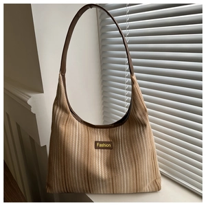 Detail of striped canvas tote bag with leather straps and Fashion patch ornament