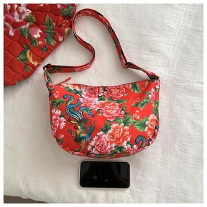 Close-up of ethnic floral canvas bag with a phone for size reference and scale