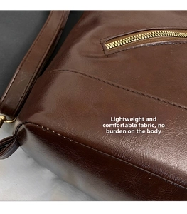 Detail of dark brown leather tote showing premium texture and fine stitching crafts