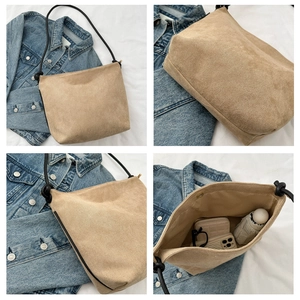 Detail view of khaki suede bucket bag featuring black rope straps and large capacity