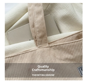 Detailed close-up of the reinforced stitching and soft corduroy fabric on this tote bag