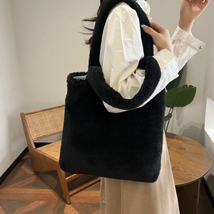 Close-up of black plush faux fur tote bag with wide strap for autumn winter fashion