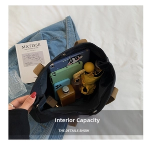 Detail of spacious interior of black canvas tote bag with magnetic closure and daily items