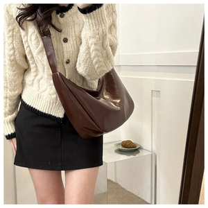 Brown faux leather half-moon shoulder bag styled with a beige cardigan for daily wear