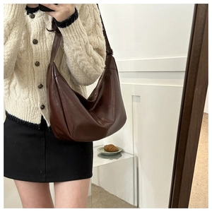 Gros plan du sac Hobo marron foncé minimaliste avec texture cuir huilé et bandoulière large