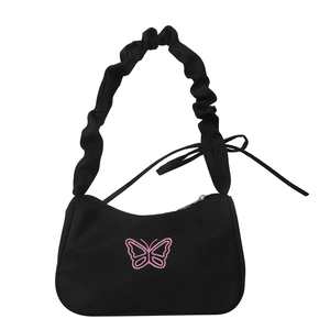 Minimalist black canvas shoulder bag featuring pink butterfly embroidery and ruffled strap