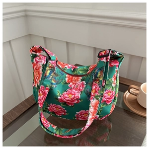 Detail of green canvas crossbody bag featuring traditional red peony and phoenix prints