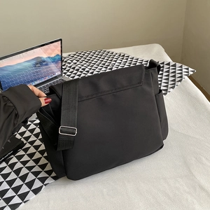 Minimalist black nylon messenger bag with adjustable strap and large capacity